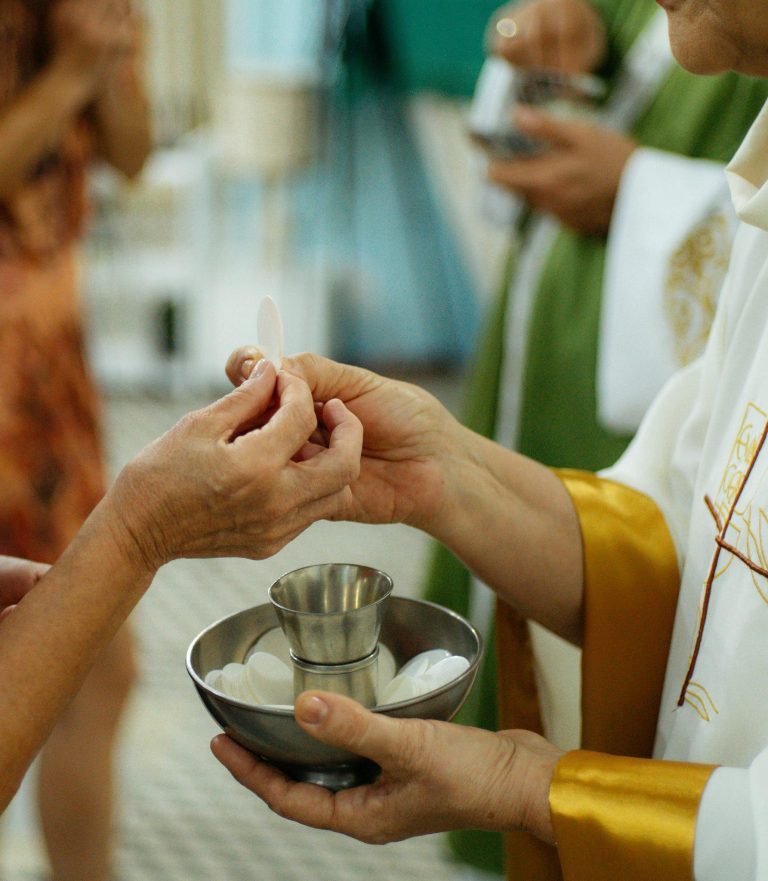 A priest gives Communion during a church service, showing the sacred rituals of Christianity.